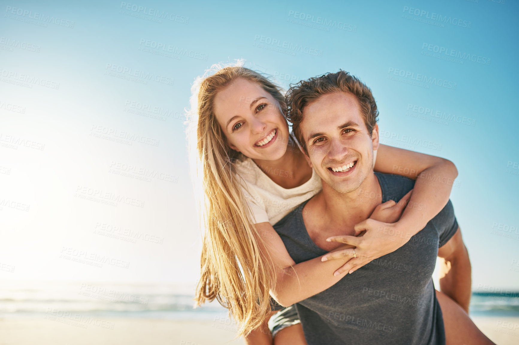 Buy stock photo Portrait, piggy back and beach with couple, smile and sunshine with happiness, honeymoon and romance. Face, seaside and man carrying woman with vacation, journey and summer with getaway trip or love