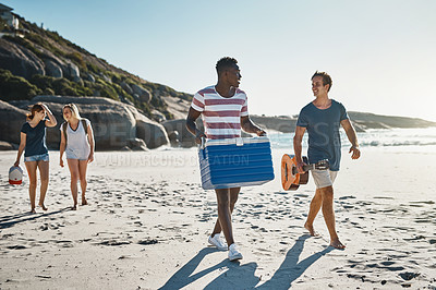 Buy stock photo Shot of a group of young friends walking on the beach on a sunny day