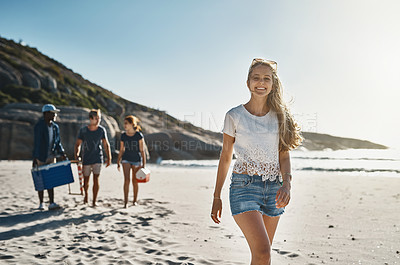 Buy stock photo Portrait of a happy young woman walking on the beach with her friends on a sunny day
