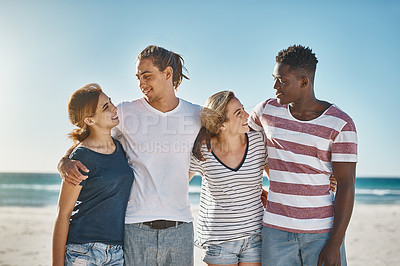 Buy stock photo Shot of a group of happy young friends posing on the beach together