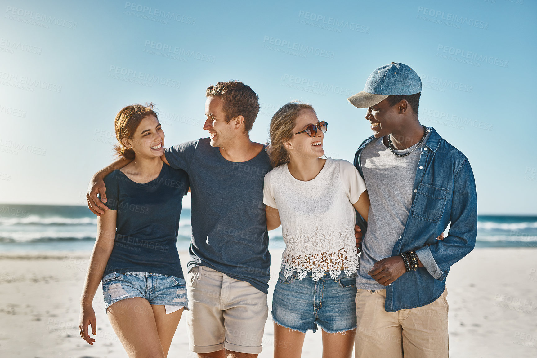 Buy stock photo Shot of a group of happy young friends posing on the beach together