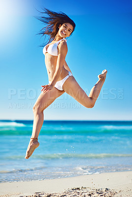 Buy stock photo Portrait of a beautiful young woman in a bikini jumping in the air on the beach