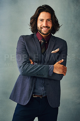 Buy stock photo Studio portrait of a stylishly dressed handsome young man standing with his arms crossed