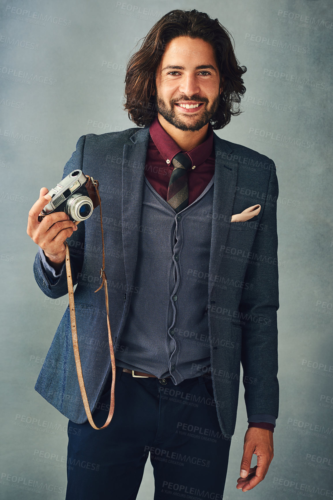 Buy stock photo Studio portrait of a stylishly dressed handsome young man holding a vintage camera