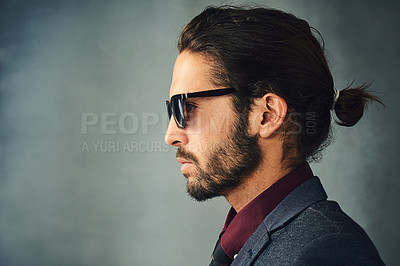 Buy stock photo Studio profile shot of a stylishly dressed handsome young man with a ponytail wearing sunglasses