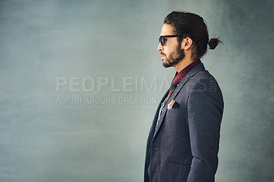 Buy stock photo Studio profile shot of a stylishly dressed handsome young man with a ponytail wearing sunglasses