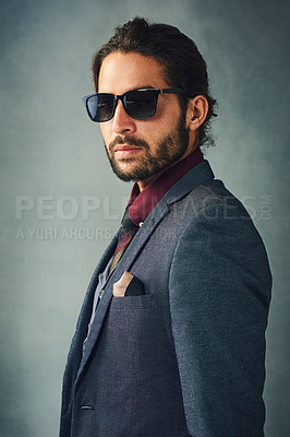 Buy stock photo Studio portrait of a stylishly dressed handsome young man wearing sunglasses