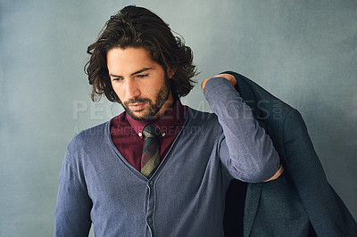 Buy stock photo Studio shot of a stylishly dressed handsome young man with his jacket over his shoulder