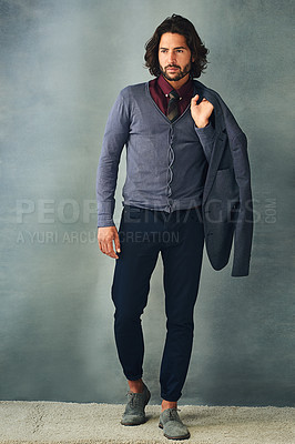 Buy stock photo Studio shot of a stylishly dressed handsome young man with his jacket over his shoulder