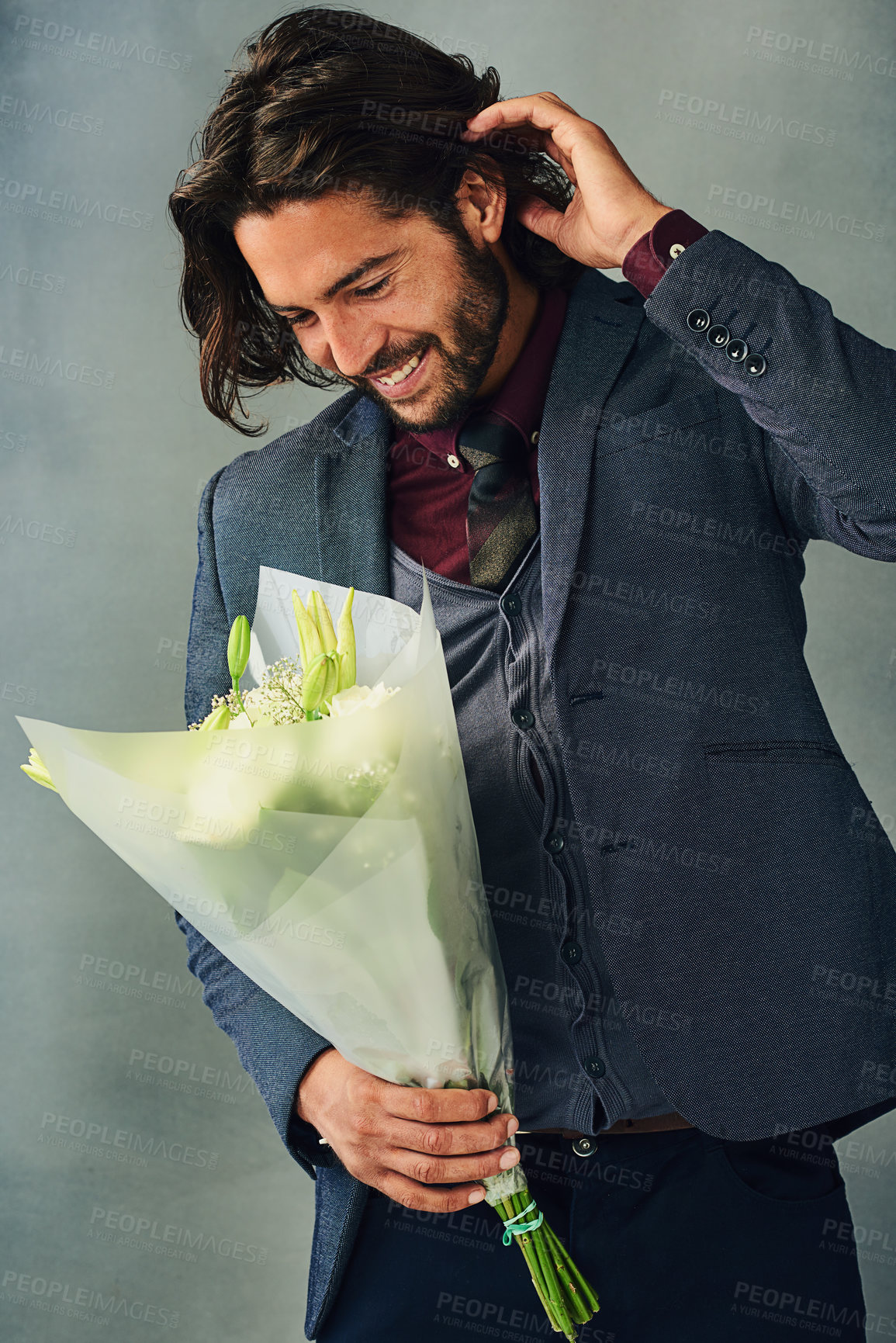 Buy stock photo Flowers, shy and smile with man in suit on studio gray background for romance or valentines day. Bouquet, fashion and love with happy person in formal outfit for anniversary or celebration event