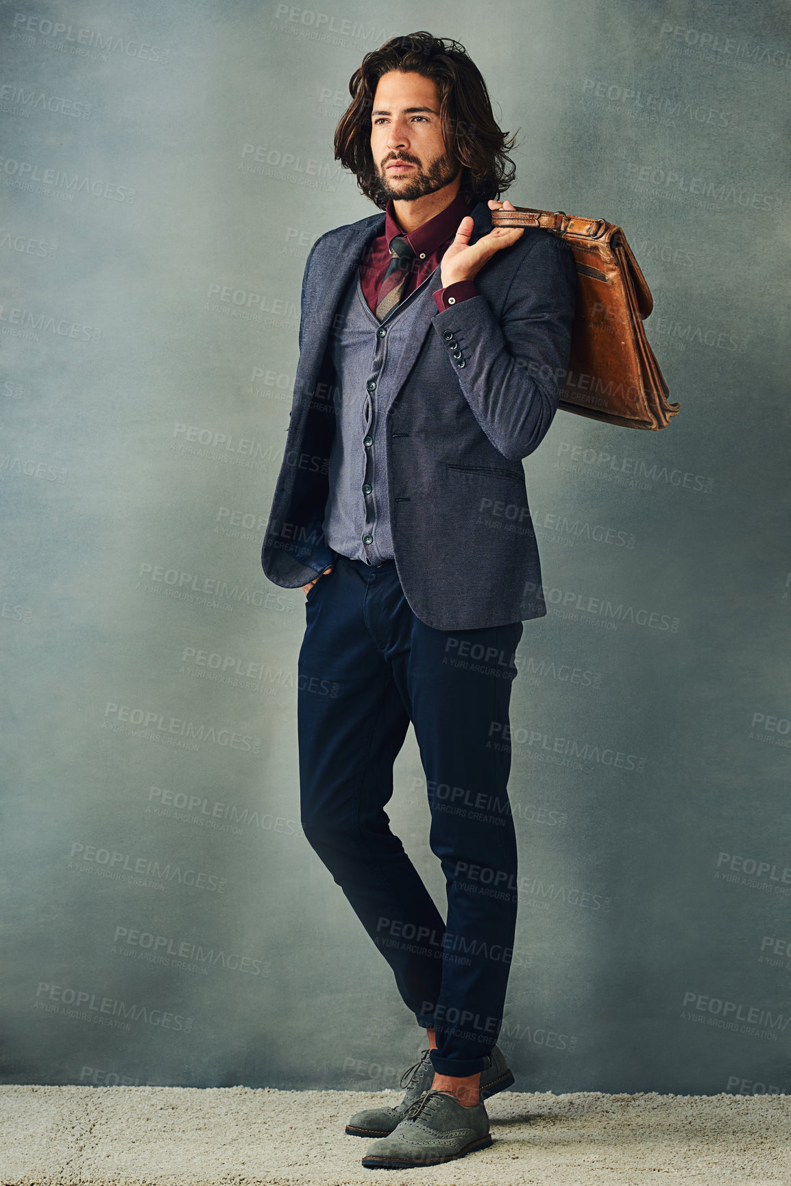 Buy stock photo Studio shot of a stylishly dressed handsome young man with his bag over his shoulder