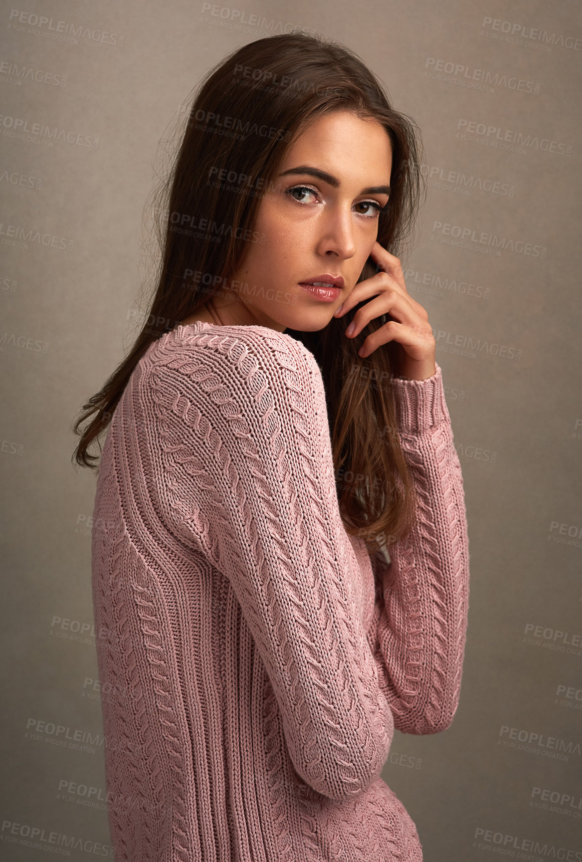 Buy stock photo Shot of a beautiful young woman posing against a brown background