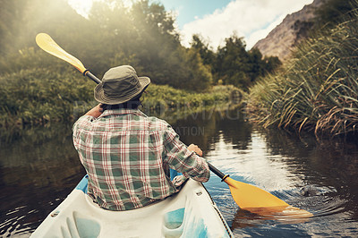 Buy stock photo Rearview shot of a young man going for a canoe ride on the lake