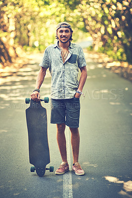 Buy stock photo Portrait of a young man standing in the street with his longboard