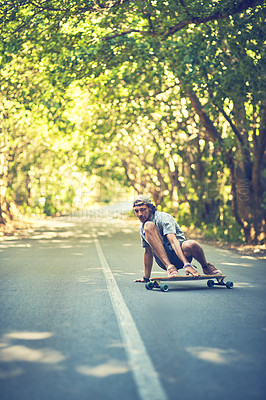 Buy stock photo Shot of a young man longboarding in the street