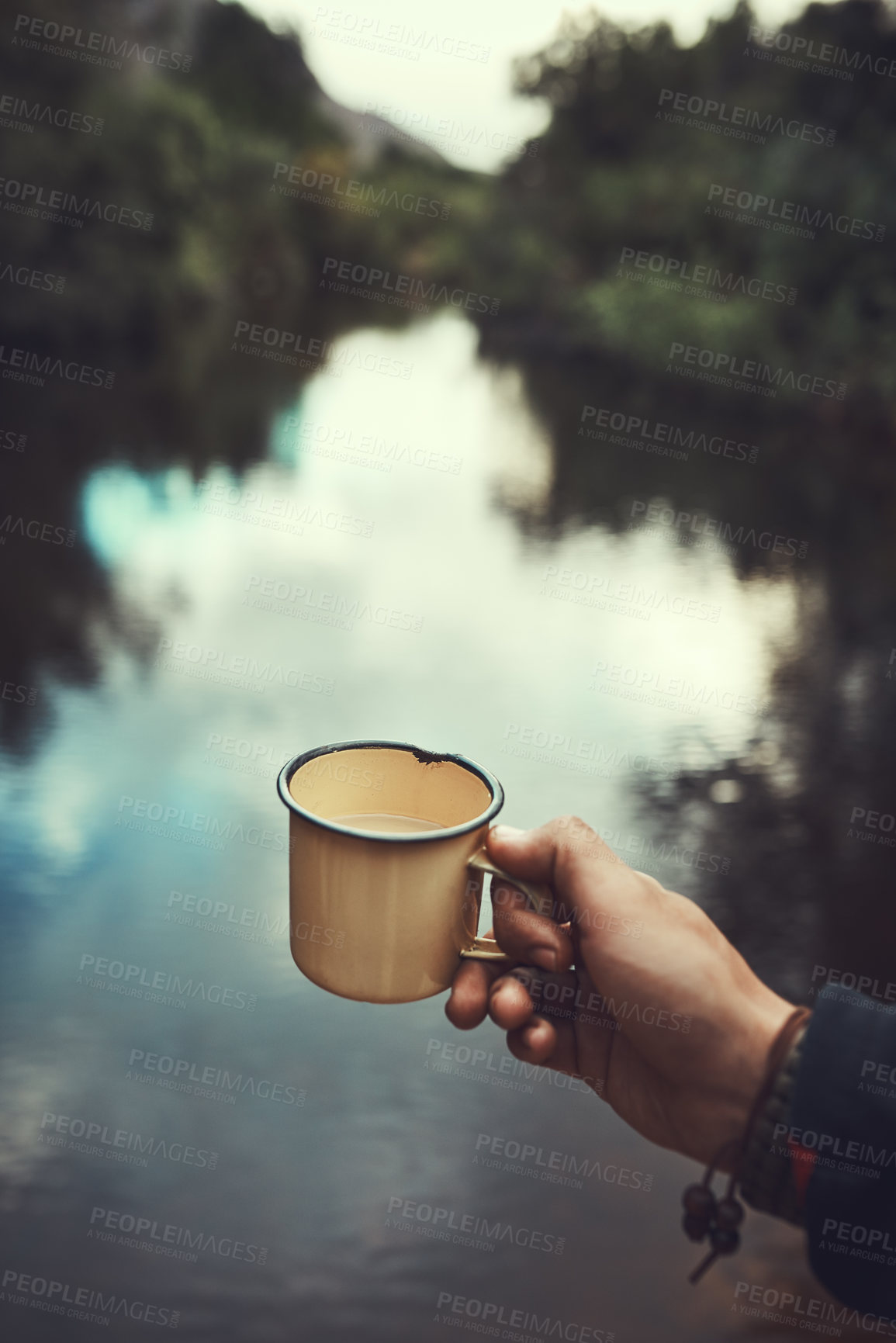 Buy stock photo Cropped shot of an unidentifiable man holding a mug with the river in the background
