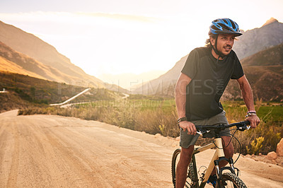 Buy stock photo Cropped shot of a young man cycling along a trail