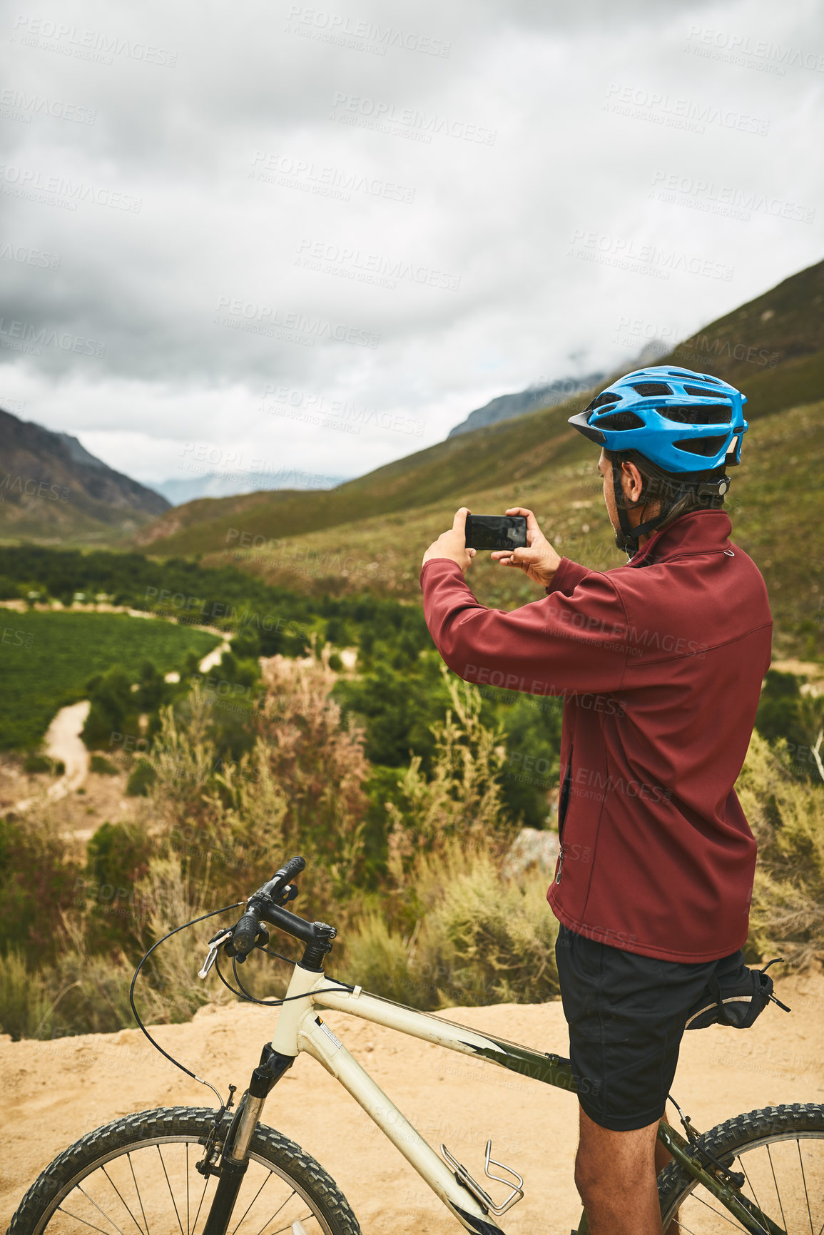 Buy stock photo Bike, phone and photograph with man in mountains for cycling, exercise or fitness to improve cardio. Bicycle, nature and memory with cyclist outdoor in green environment for training or workout