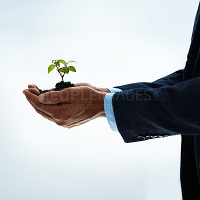Buy stock photo Closeup shot of an unidentifiable businessman holding a plant growing in soil