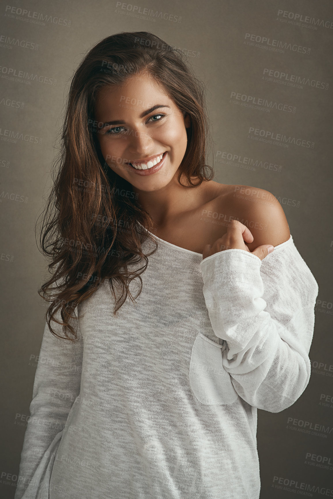 Buy stock photo Portrait of a beautiful young woman smiling against a brown background in studio