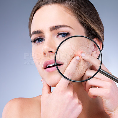 Buy stock photo Cropped shot of a young woman squeezing a pimple on her face against a grey background