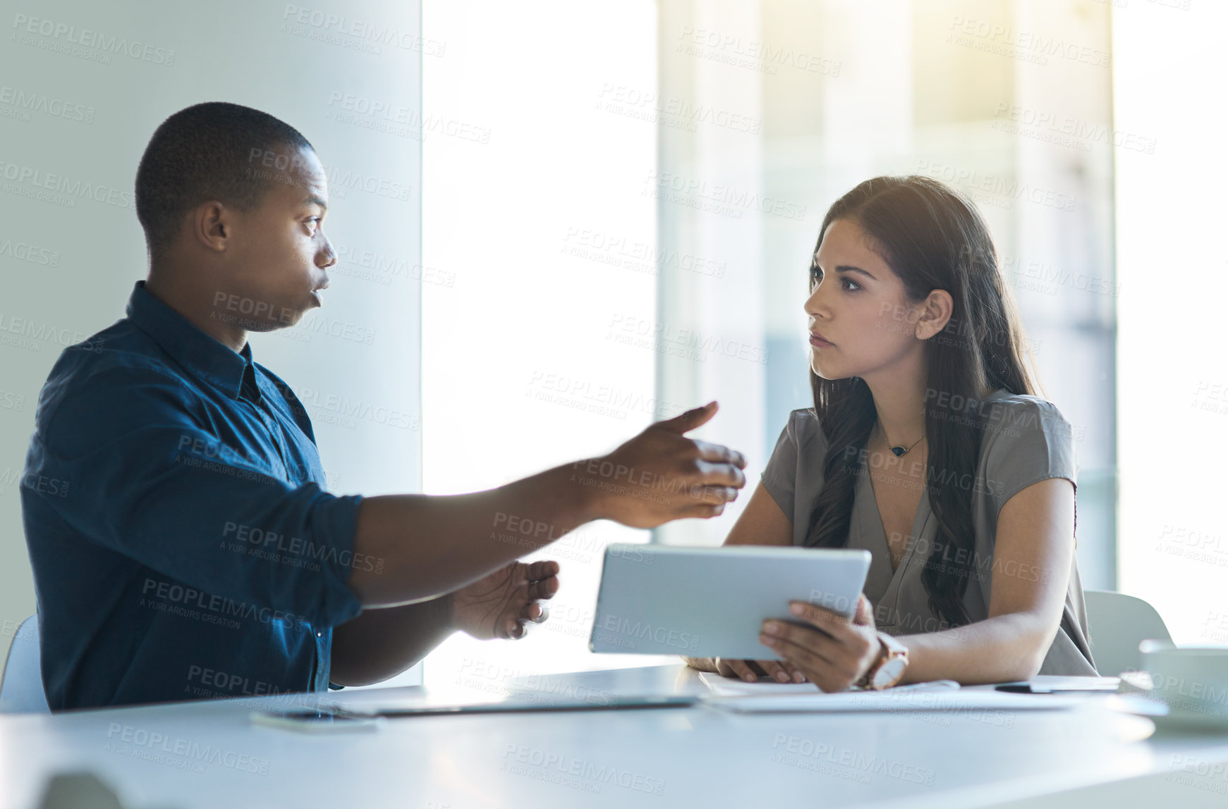 Buy stock photo Cropped shot of two colleagues having a discussion in an office