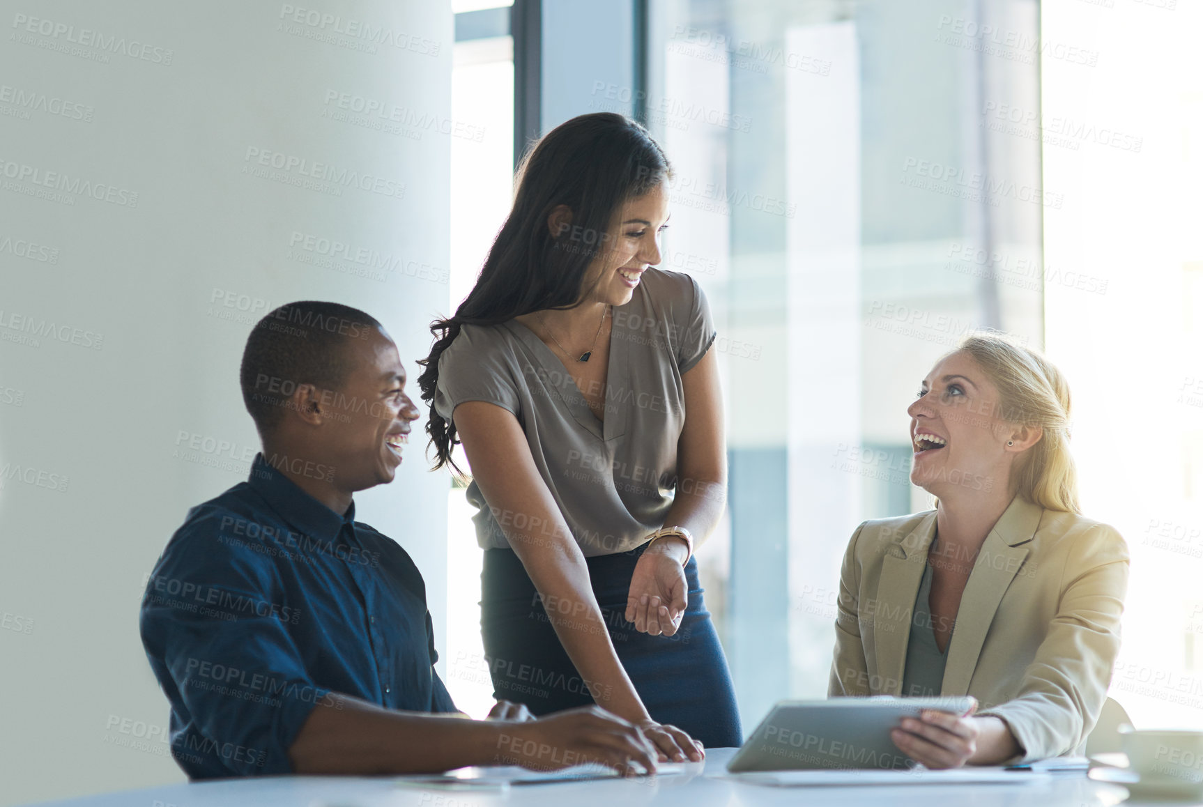Buy stock photo Cropped shot of a group of colleagues laughing while having a discussion in an office