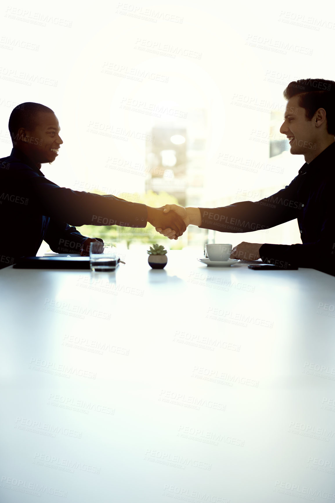 Buy stock photo Cropped shot of two businesspeople shaking hands in an office