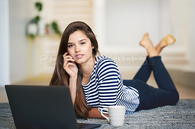 Buy stock photo Portrait of a smiling young woman lying on the floor at home using a laptop