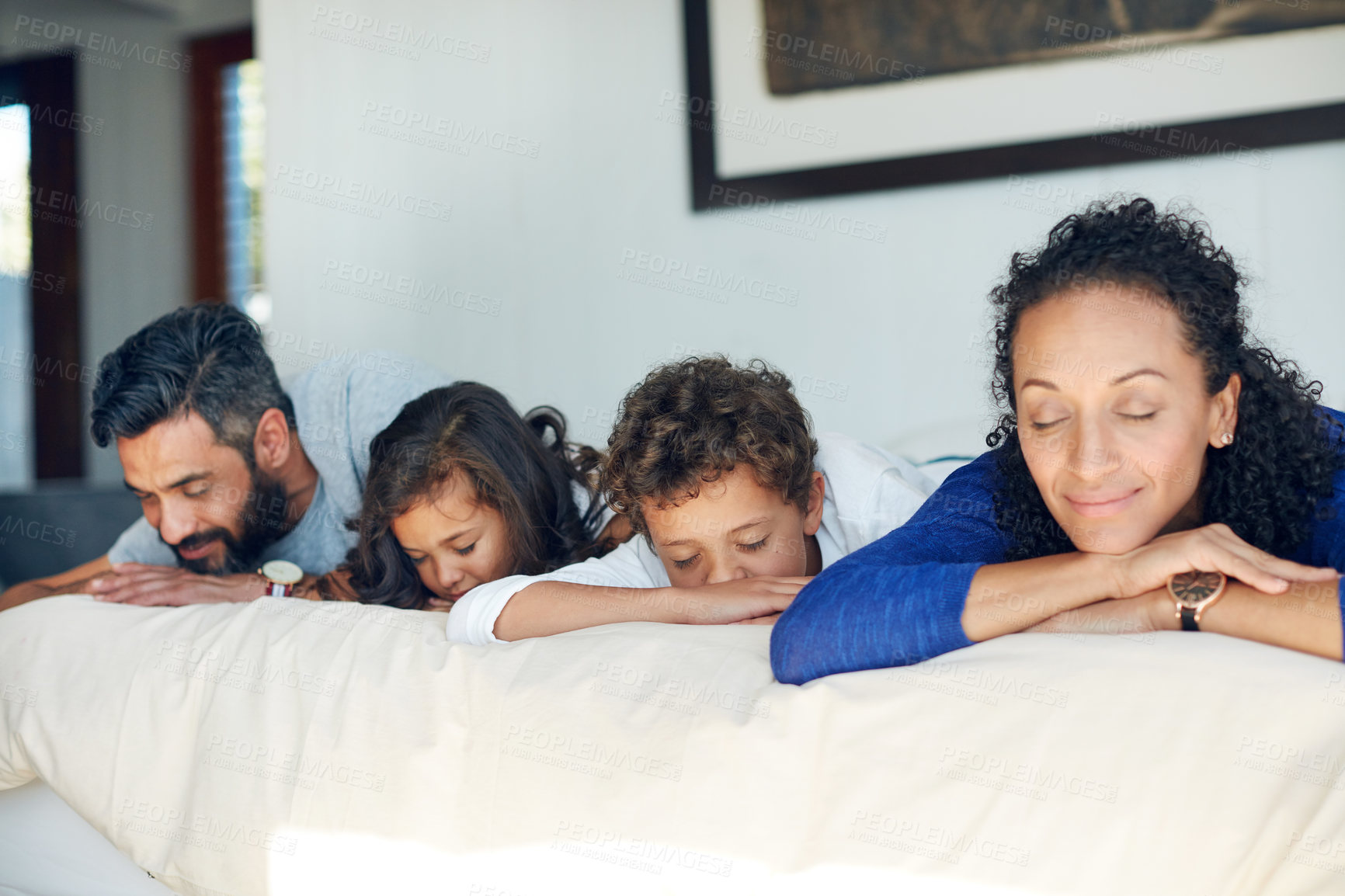 Buy stock photo Cropped shot of a family lying down on a bed with their eyes closed at home