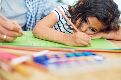 Buy stock photo Cropped shot of a little girl colouring in with her father at home