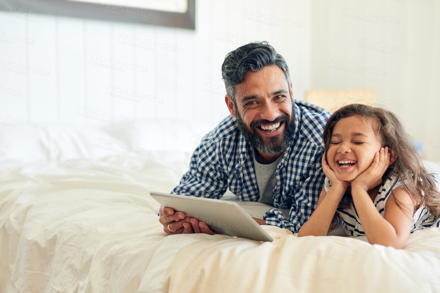 Buy stock photo Bed, digital tablet and girl laughing with father, relax and sharing comic or joke in their home together. Happy, comedy and parent and with girl in bedroom online for funny meme or subscription