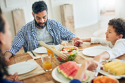 Buy stock photo Shot of a family praying together before enjoying a meal at the table