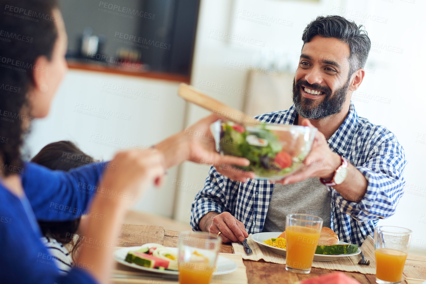 Buy stock photo Shot of a happy family gathered around their table for a meal