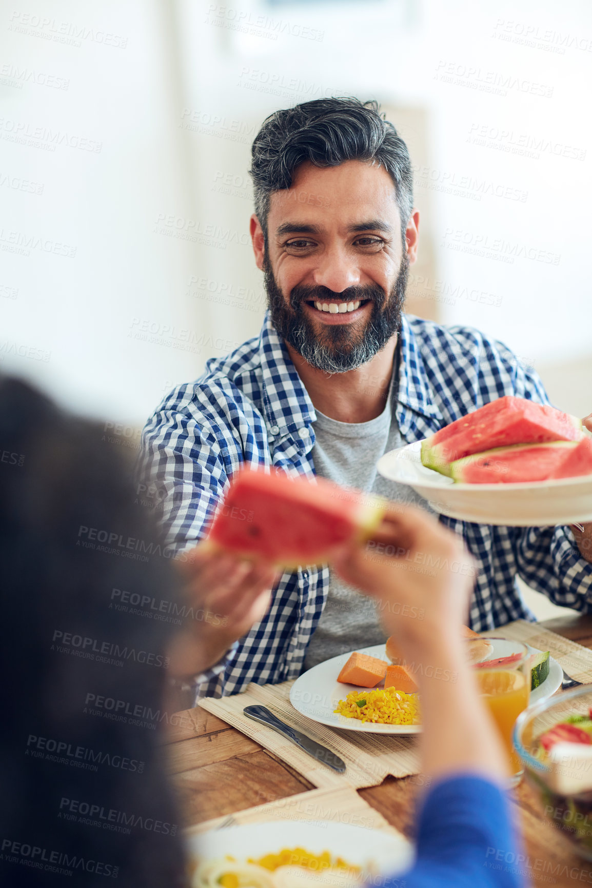 Buy stock photo Shot of a happy family gathered around their table for a meal