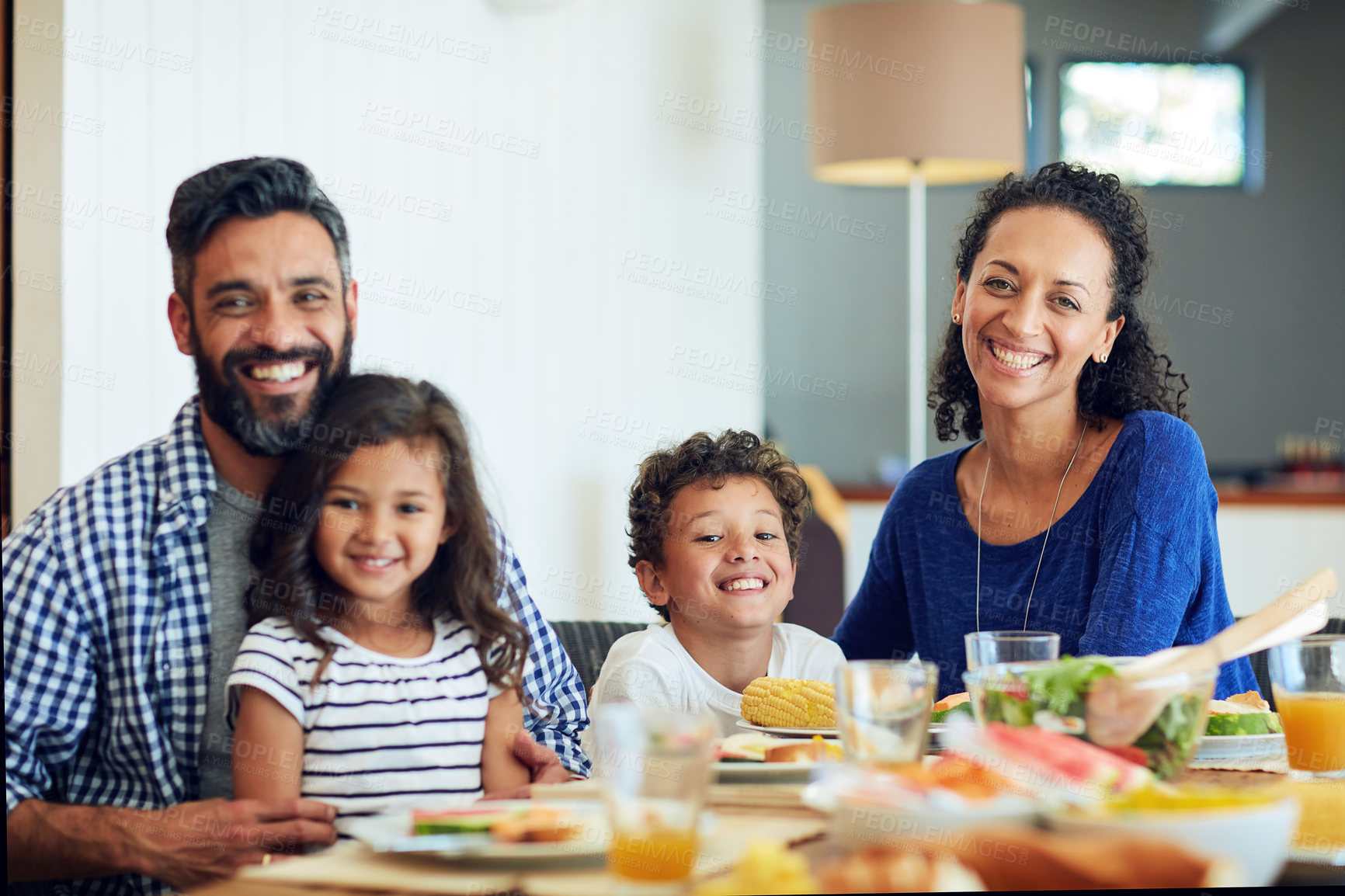 Buy stock photo Portrait of a happy family gathered around their table for a meal