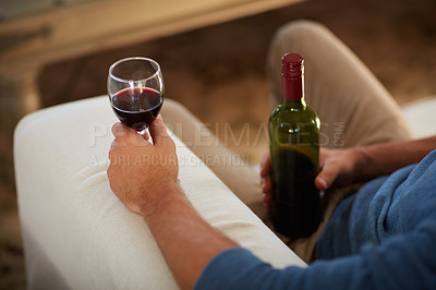 Buy stock photo Cropped shot of an unidentifiable man drinking wine at home