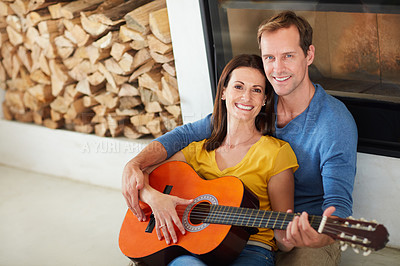 Buy stock photo Portrait of a mature couple playing the guitar together at home
