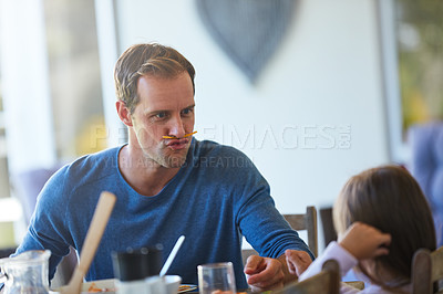 Buy stock photo Cropped shot of a father and his little daughter enjoying a meal together at home