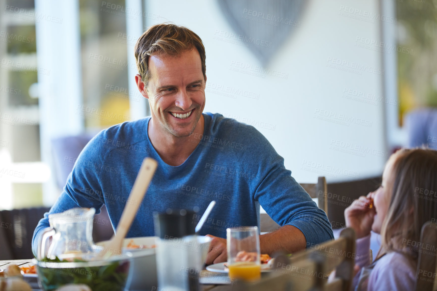 Buy stock photo Cropped shot of a father and his little daughter enjoying a meal together at home