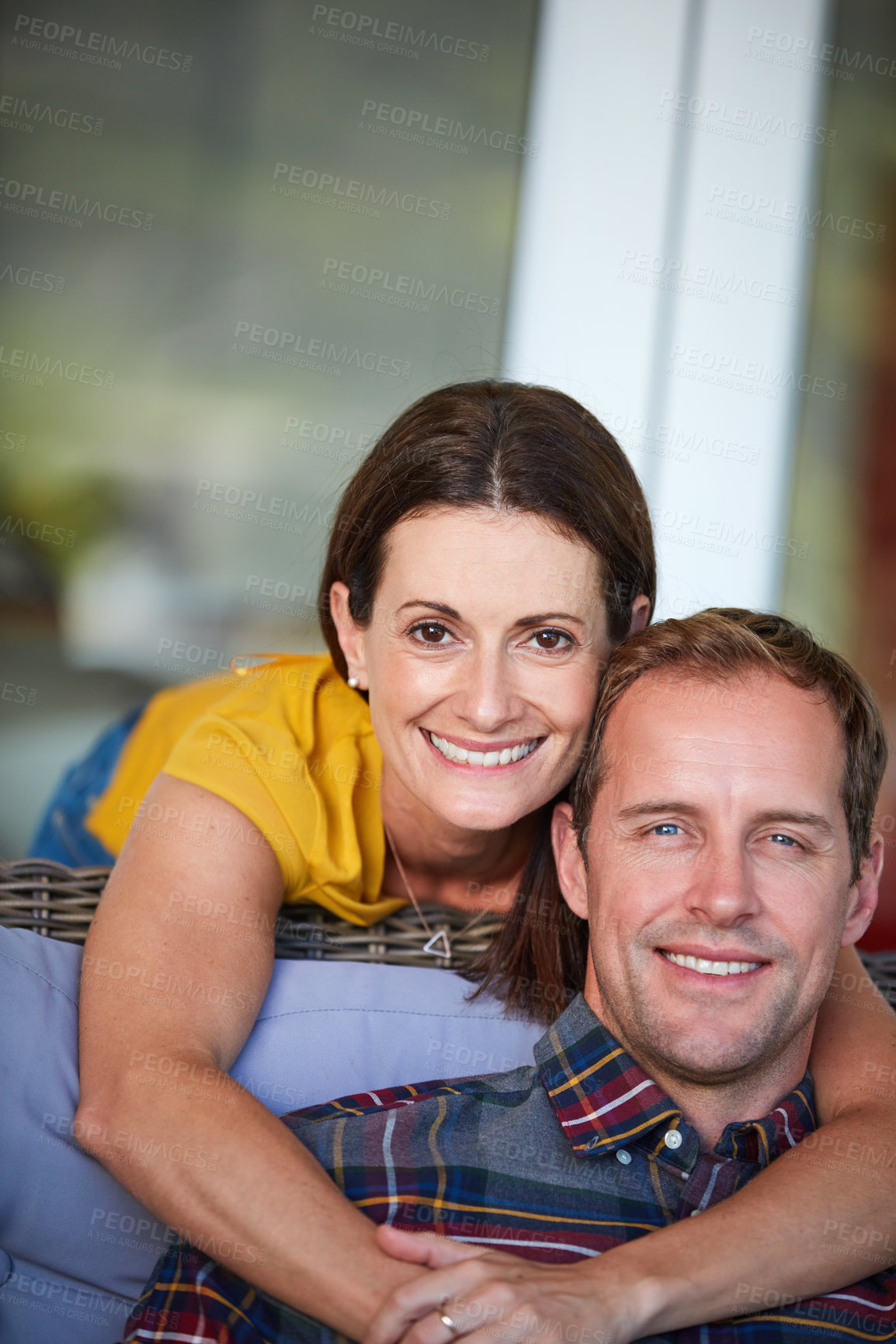 Buy stock photo Cropped shot of a woman hugging her husband from behind