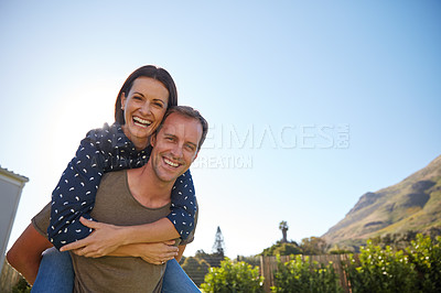 Buy stock photo Cropped shot of a man giving his wife a piggyback ride