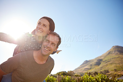 Buy stock photo Cropped shot of a man giving his wife a piggyback ride
