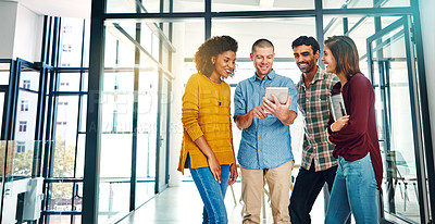 Buy stock photo Cropped shot of four young coworkers talking while looking at a digital tablet