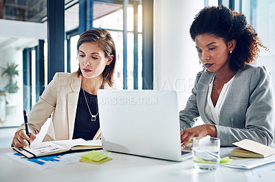 Buy stock photo Cropped shot of two corporate businesswomen working together in an office