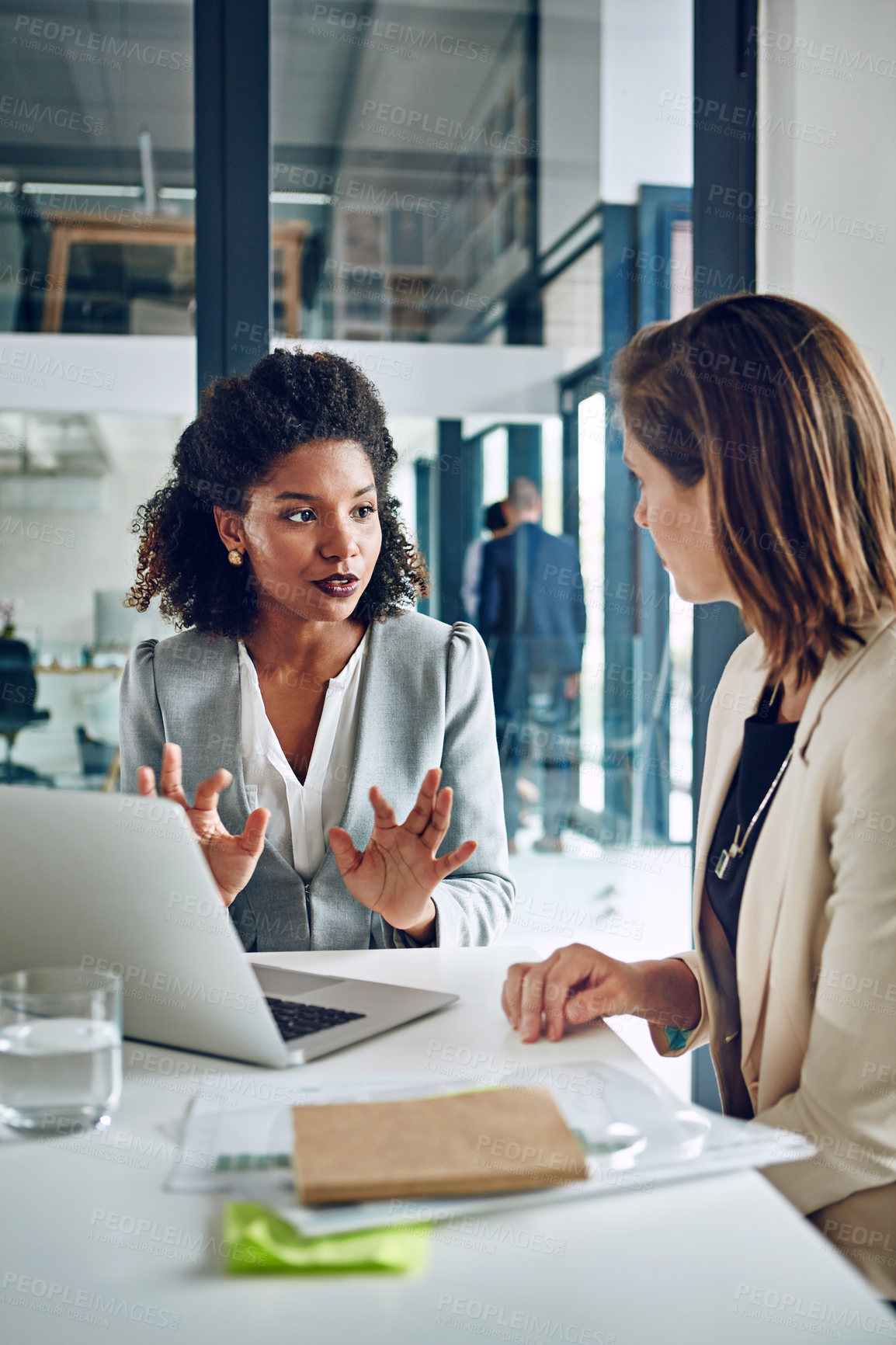 Buy stock photo Cropped shot of two corporate businesswomen having a discussion in an office