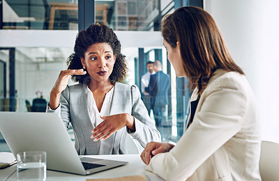Buy stock photo Cropped shot of two corporate businesswomen having a discussion in an office