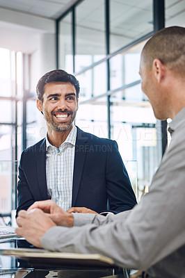 Buy stock photo Shot of two professional businessmen having a discussion at work