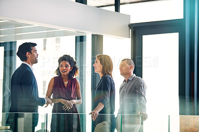 Buy stock photo Shot of a group of colleagues having a discussion in a modern office
