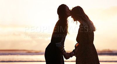 Buy stock photo Shot of two young women spending the day at the beach at sunset